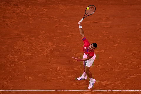 Novak Djokovic serves against Lorenzo Musetti